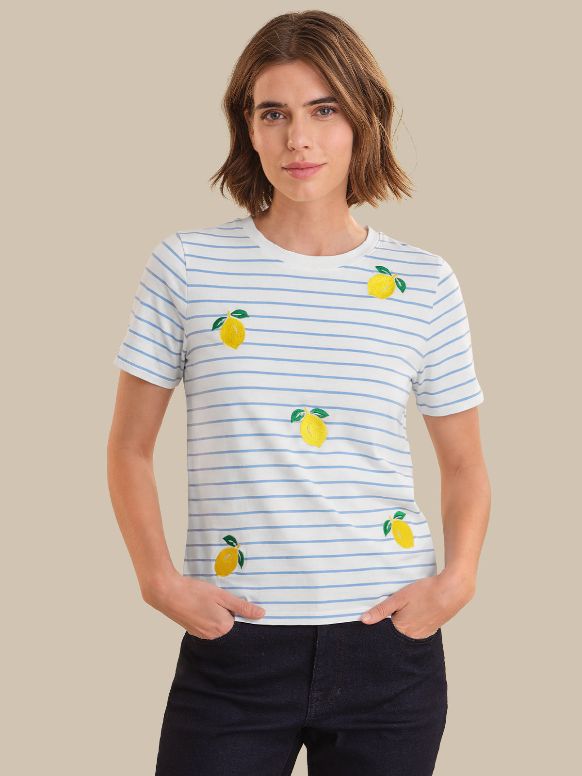 Person wearing a striped t-shirt with lemon designs on a beige background