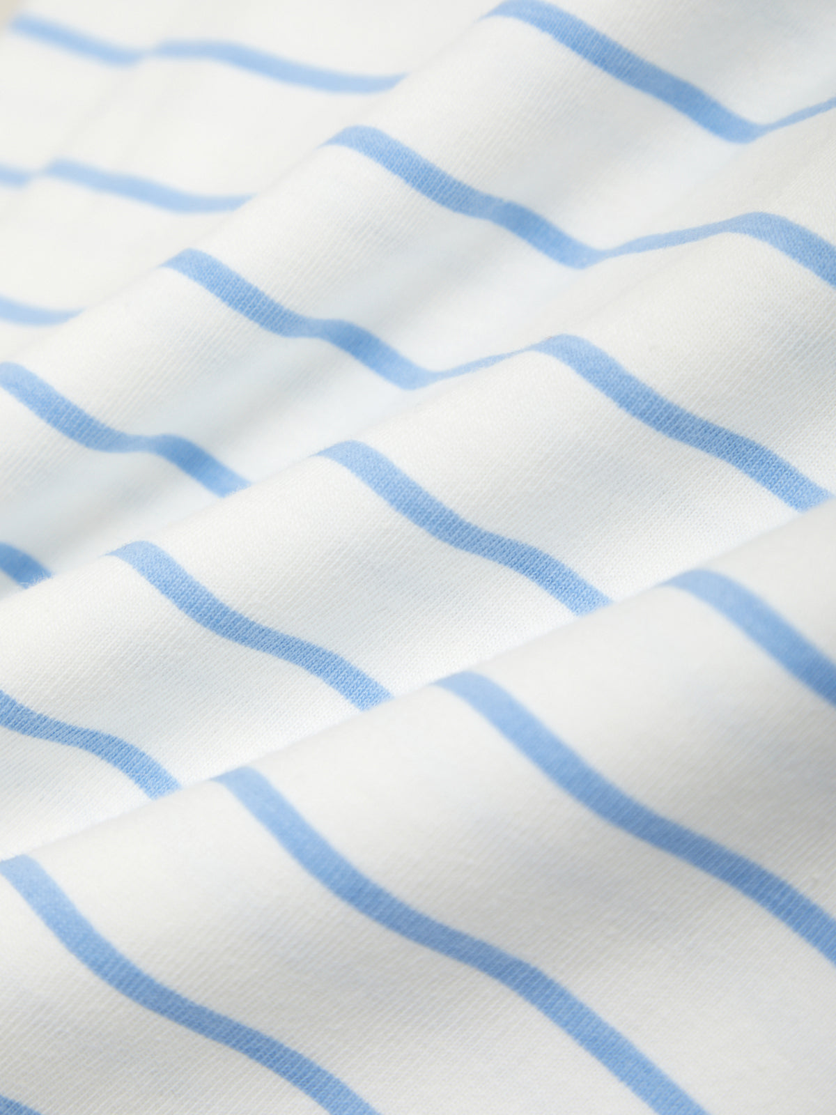 Close-up of fabric with blue wavy lines on a white background