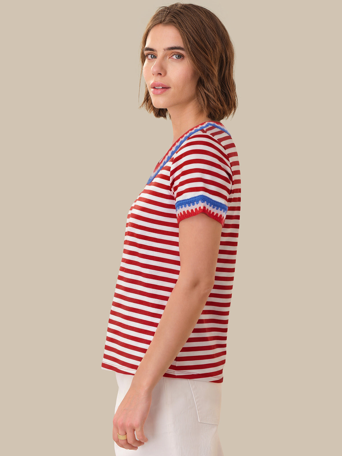 Woman wearing a red and white striped shirt with blue accents on a beige background