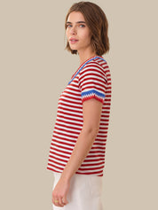 Woman wearing a red and white striped shirt with blue accents on a beige background