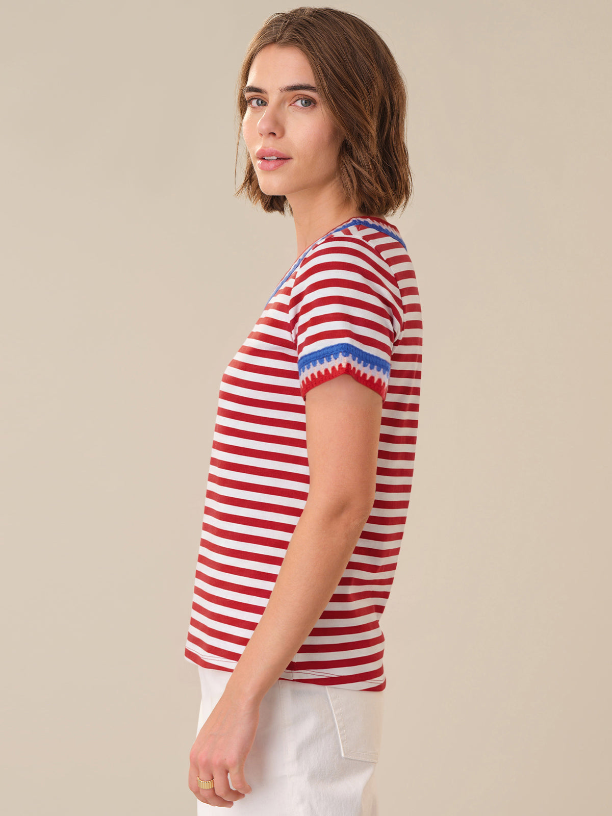 Woman wearing a red and white striped shirt with blue accents on a beige background