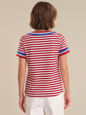 Person wearing a red and white striped shirt with blue trim on a beige background