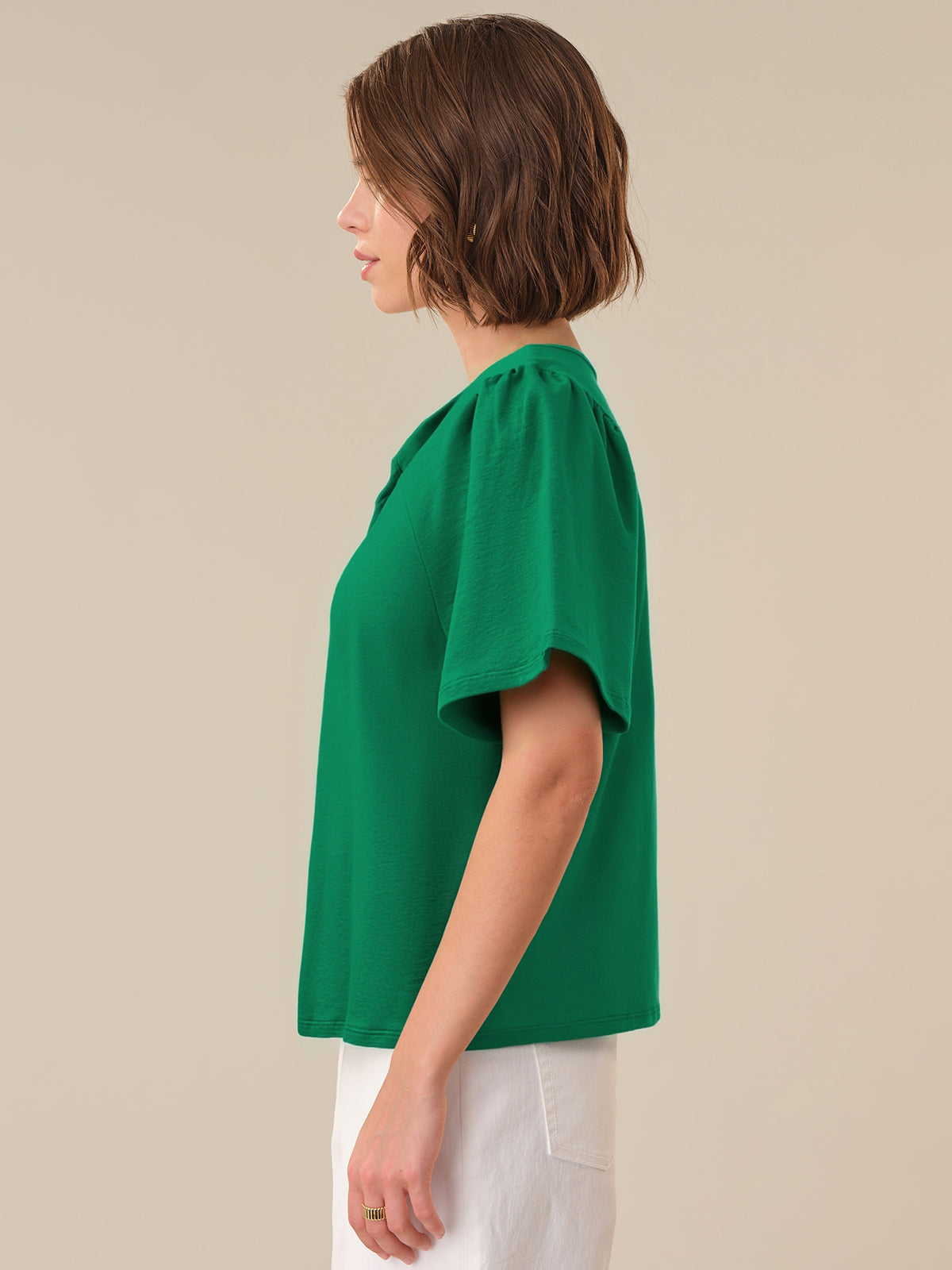 Woman wearing a green blouse against a beige background