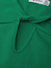 Close-up of a green garment with a brand label on a green background