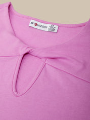 Close-up of a pink garment with a brand label on a beige background