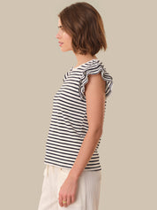 Woman wearing a black and white striped top on a beige background