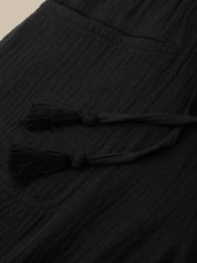 Black fabric with tassels on a beige background