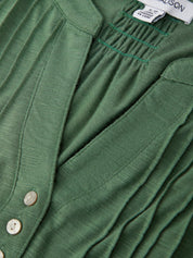 Close-up of a green garment with buttons and a brand label.