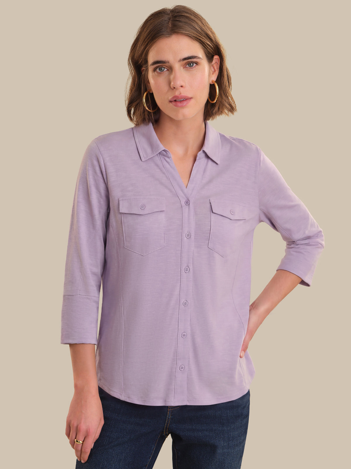 Woman wearing a light purple button-up shirt with a neutral background