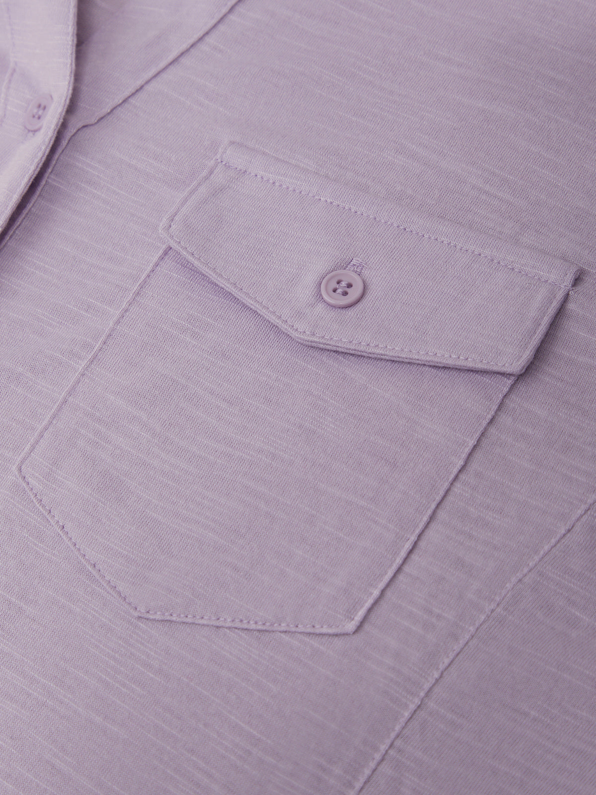 Close-up of a purple shirt with a pocket and button