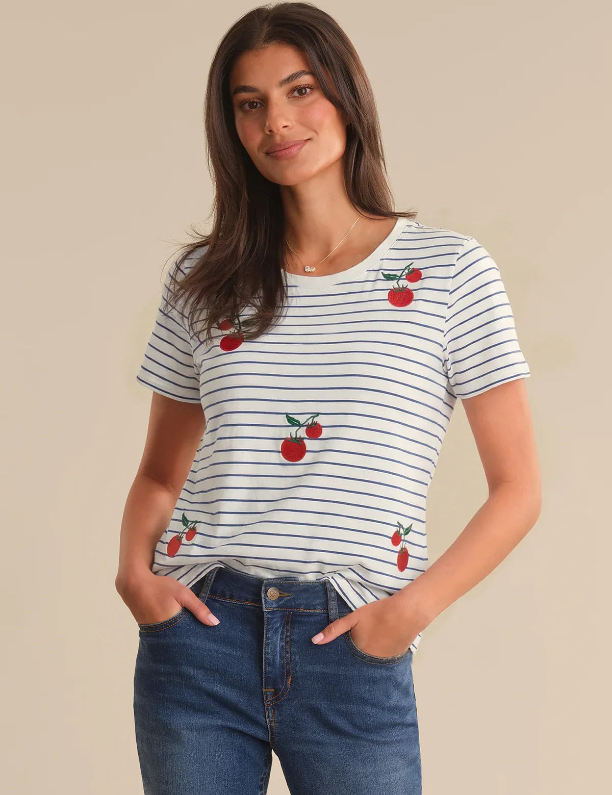Woman wearing a striped t-shirt with tomato designs on a beige background