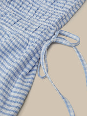 Blue and white checkered fabric with a tie on a beige background