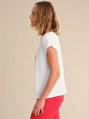 Woman wearing a white t-shirt with red accents on a beige background