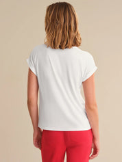 Person wearing a white t-shirt and red pants on a beige background