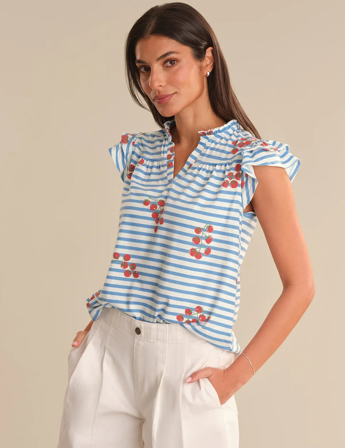 Woman wearing a blue and white striped top with red floral patterns on a beige background