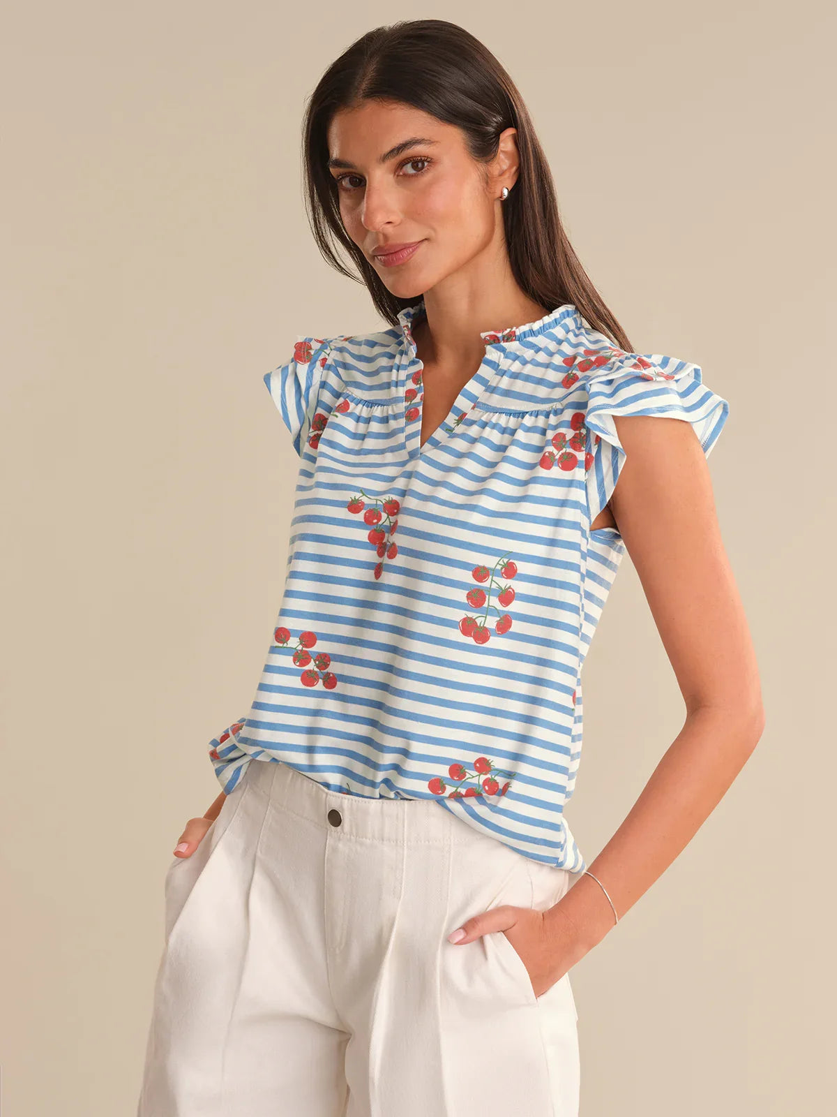 Woman wearing a blue and white striped top with red floral patterns on a beige background