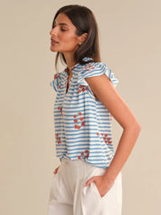 Woman wearing a blue and white striped top with red floral patterns on a beige background