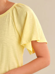 Yellow top worn by a person on a plain background