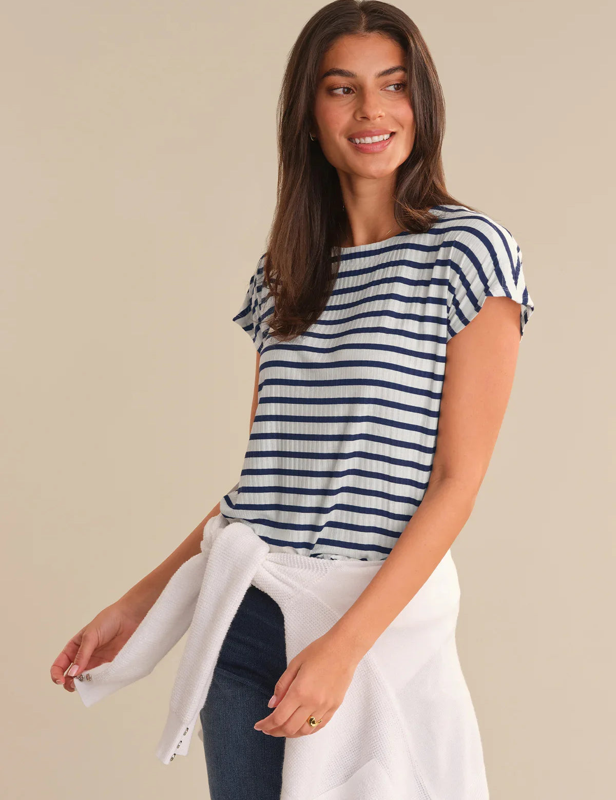 Woman wearing a blue and white striped shirt with a beige background