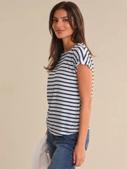 Woman wearing a navy and white striped shirt against a beige background