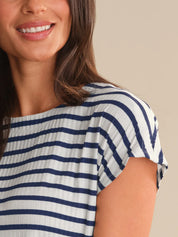 Woman wearing a blue and white striped shirt against a beige background