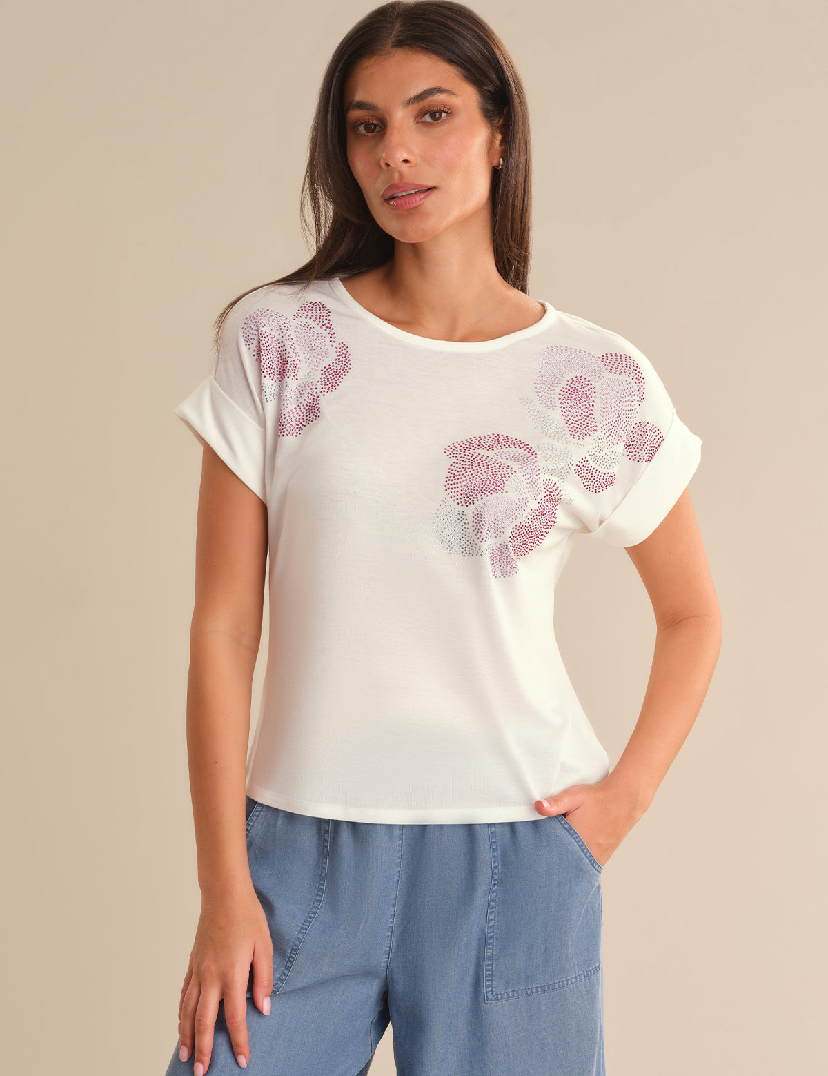 Woman wearing a white t-shirt with floral patterns on a beige background
