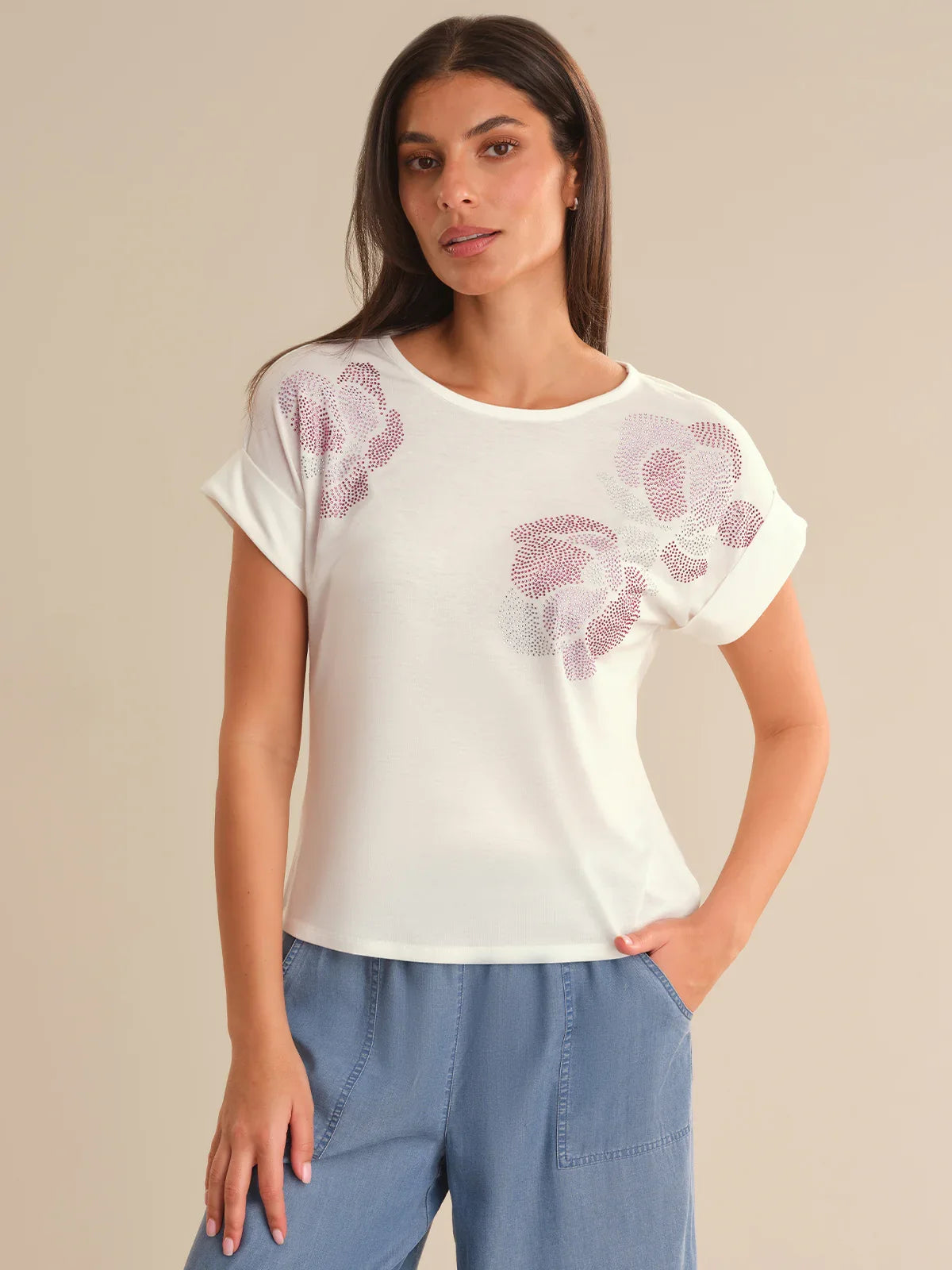 Woman wearing a white t-shirt with floral patterns on a beige background