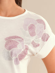 White blouse with pink floral patterns on a beige background