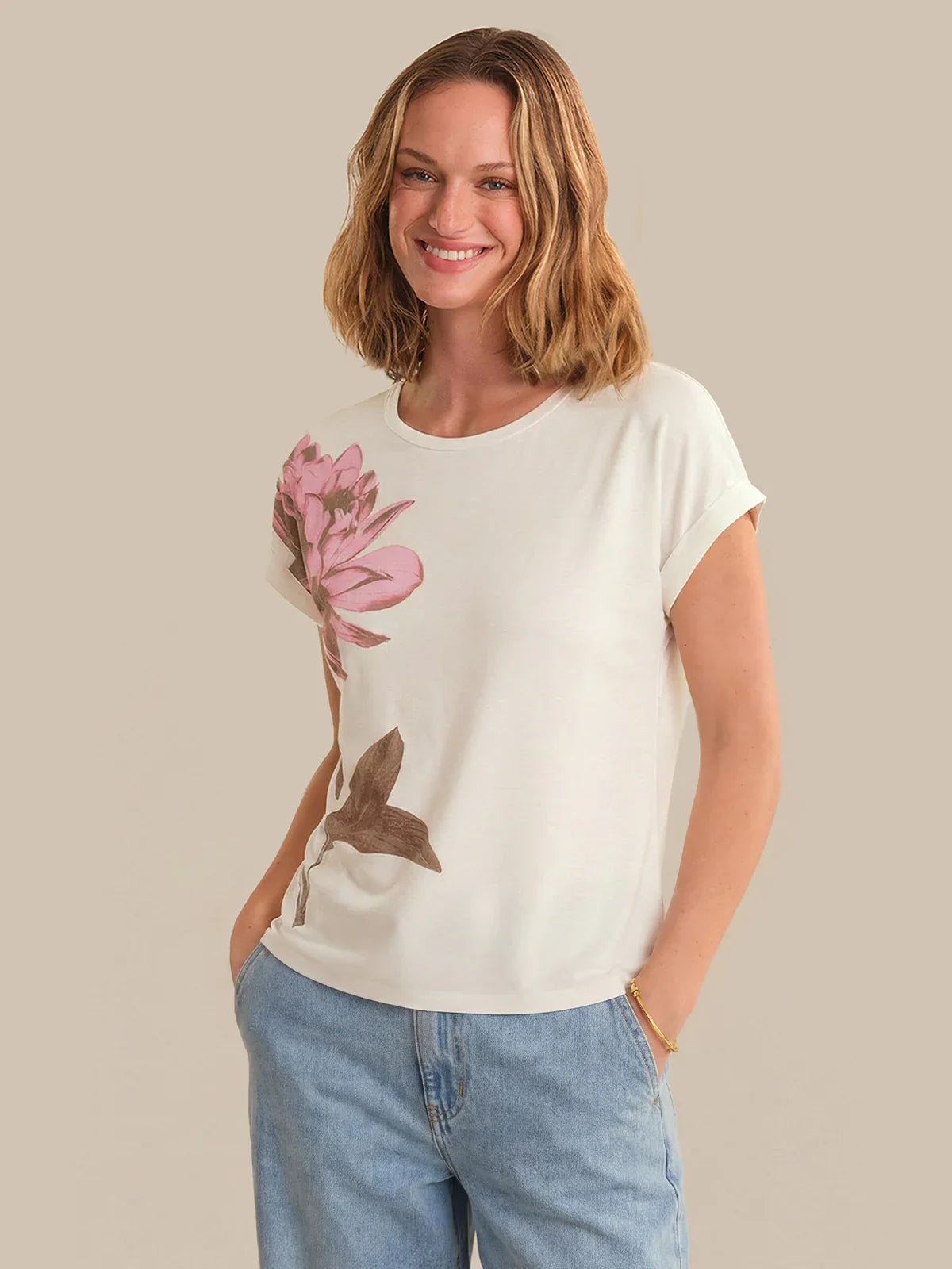 Woman wearing a white t-shirt with a floral design on a beige background
