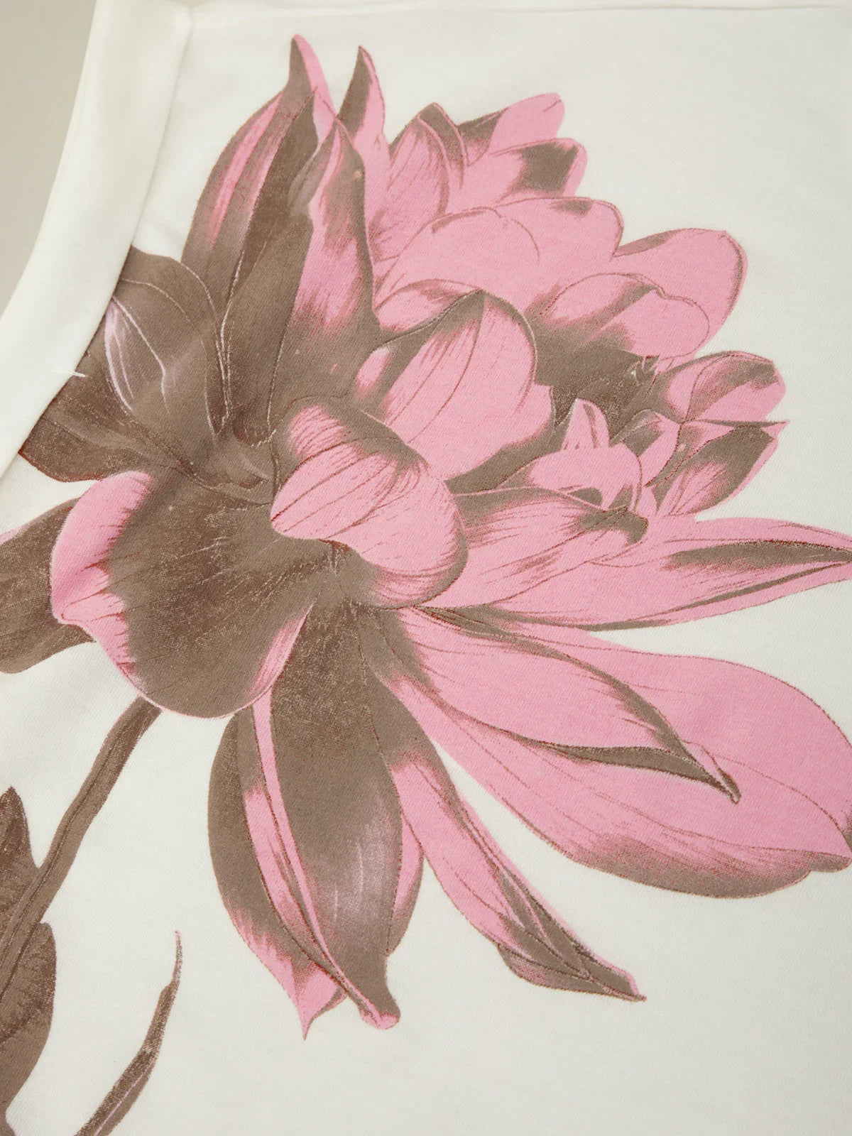 Close-up of pink and brown floral design on a fabric texture background