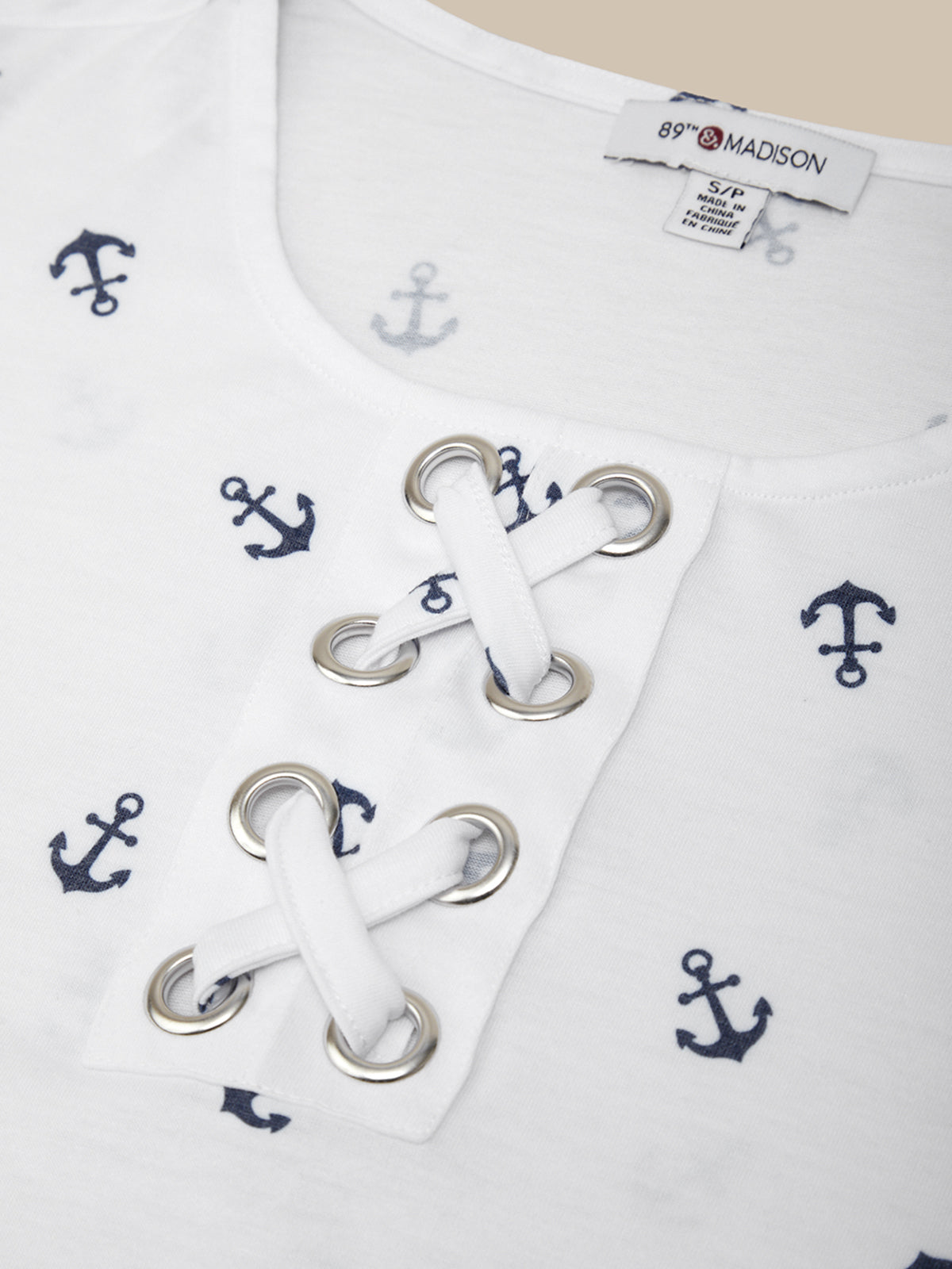 White shirt with anchor patterns and lace-up front, featuring a brand label.