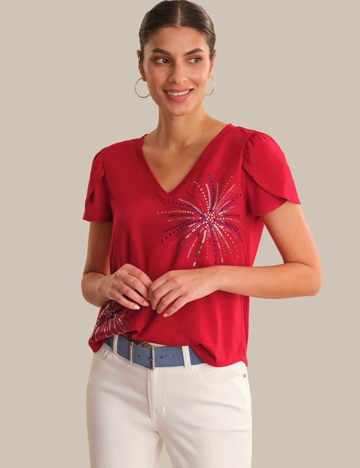 Woman wearing a red top with a decorative pattern on a beige background