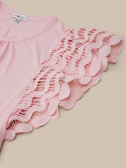 Pink top with lace detailing on a beige background