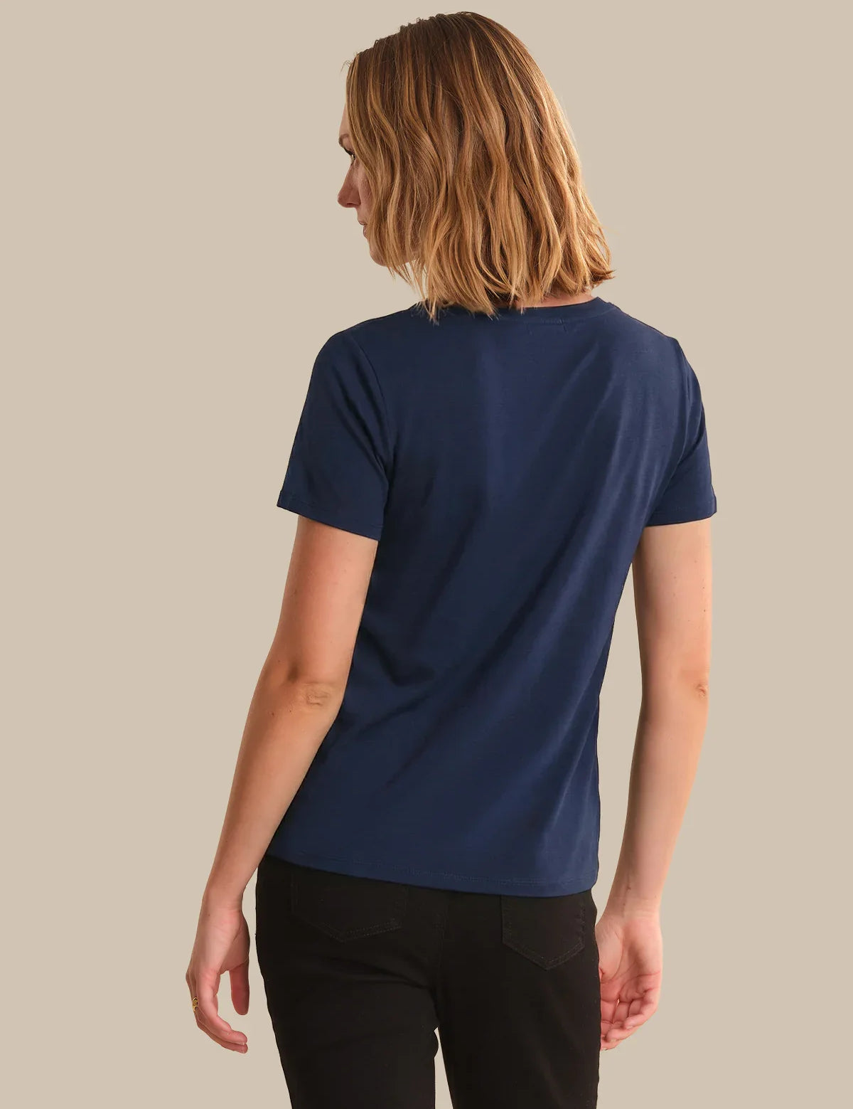 Person wearing a blue t-shirt on a beige background