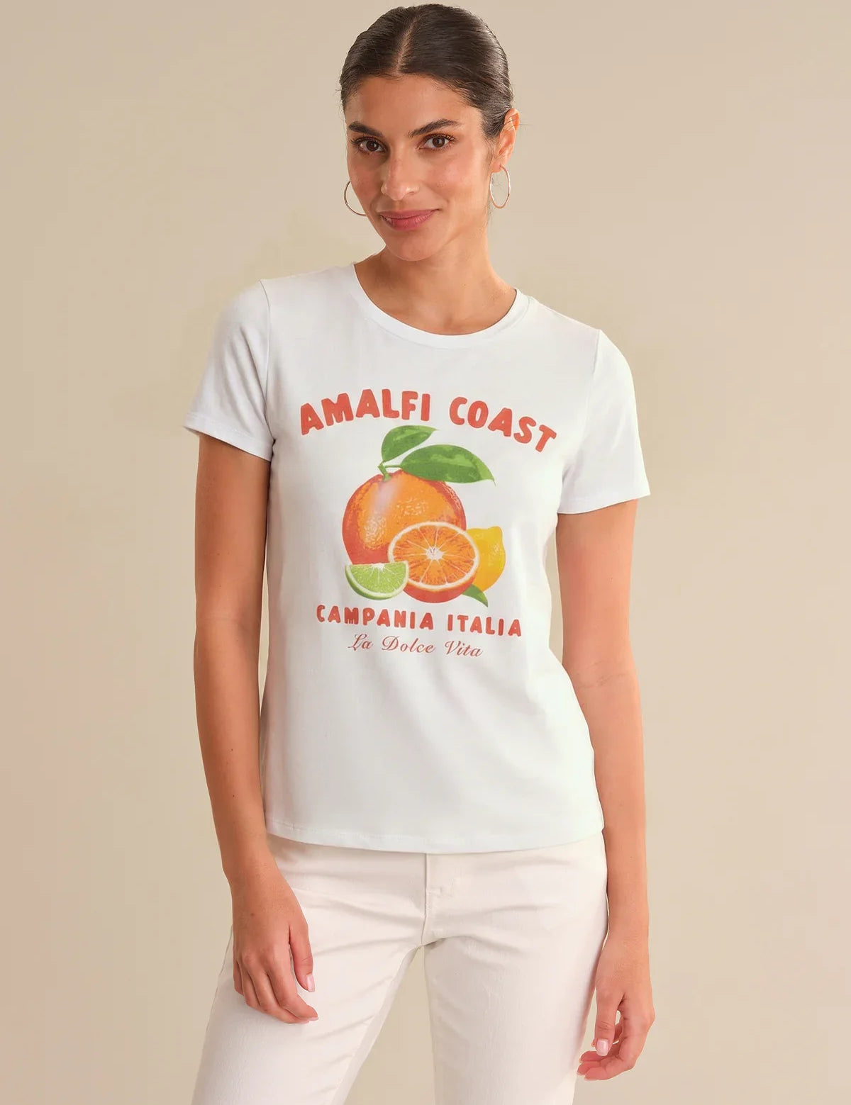 Woman wearing a white t-shirt with 'Amalfi Coast' and fruit graphic on a beige background