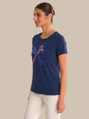 Woman wearing a blue t-shirt with a graphic design on a beige background