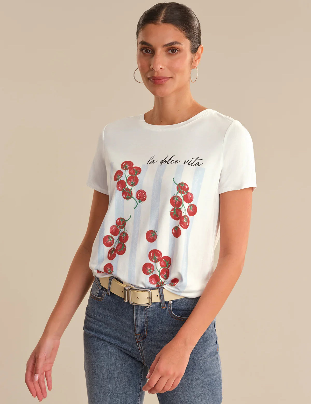Woman wearing a white t-shirt with red tomato design and text on a beige background