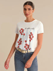 Woman wearing a white t-shirt with red tomato design and text on a beige background