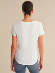 Person wearing a white t-shirt and blue jeans on a beige background