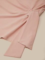 Pink fabric with a knot on a beige background