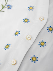 Embroidered floral patterns on a white fabric background