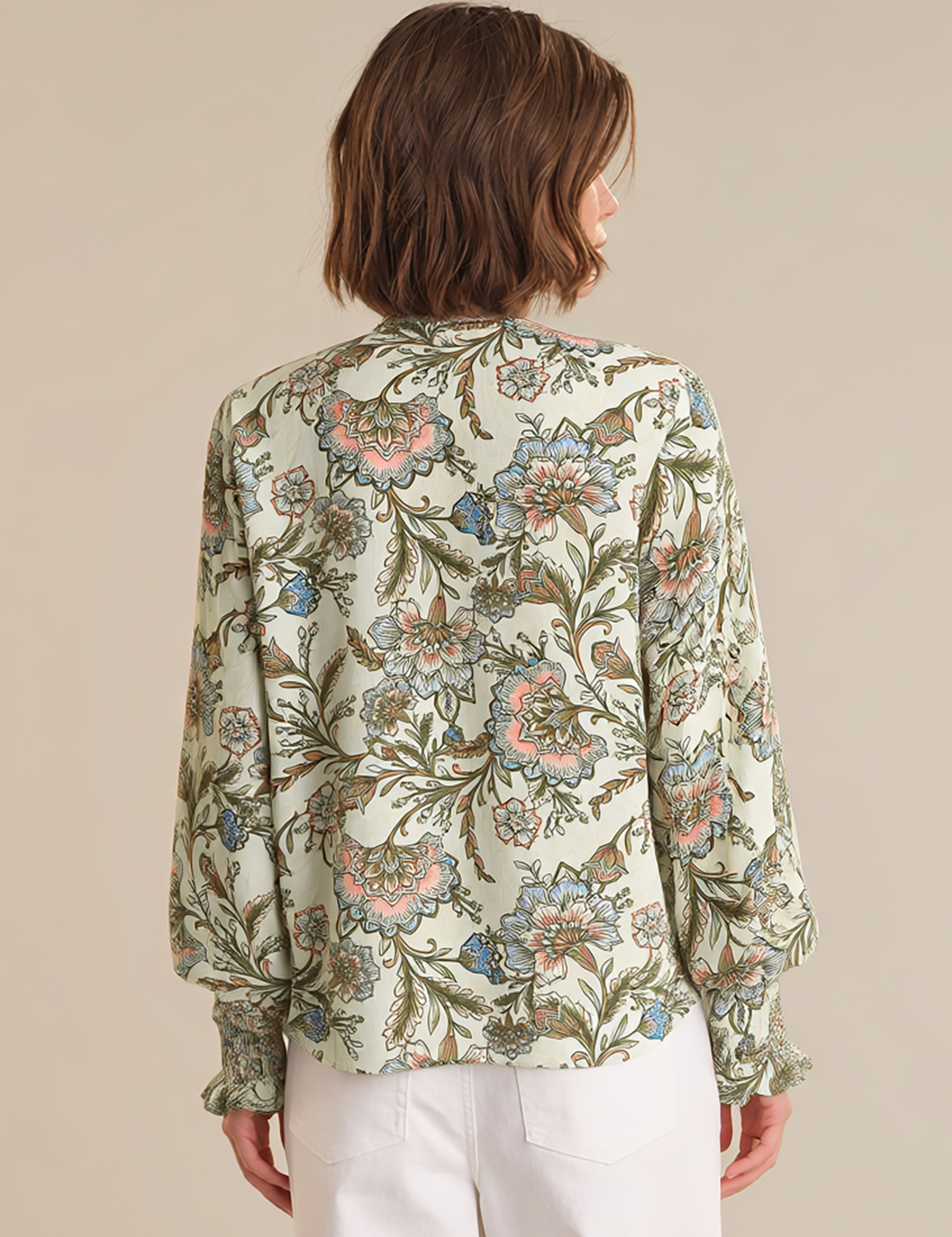 Woman wearing a floral blouse with a beige background