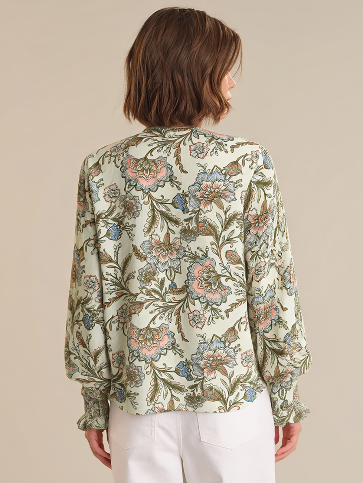 Woman wearing a floral blouse with a beige background