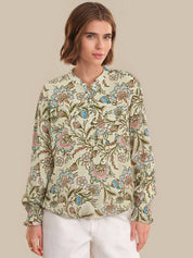 Woman wearing a floral patterned blouse against a beige background