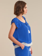 Woman wearing a blue dress with lace details on a beige background