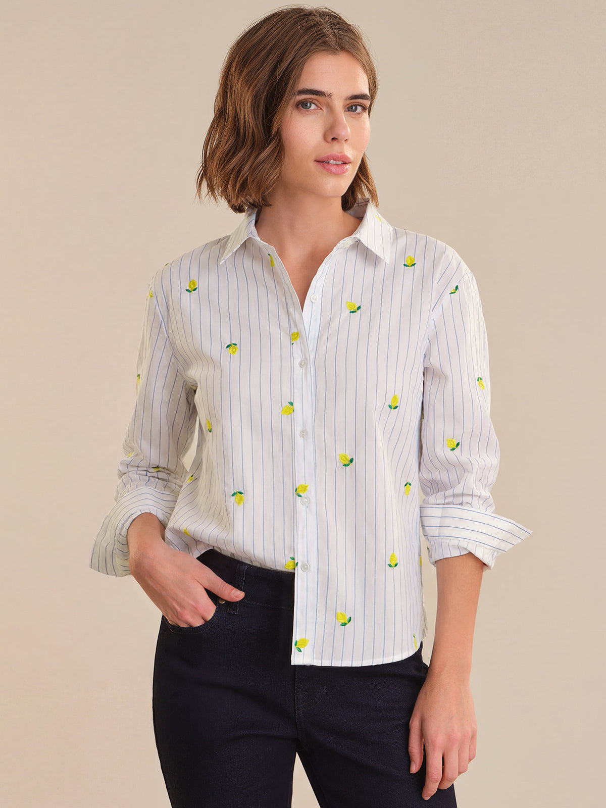 Woman wearing a white shirt with small patterns on a beige background