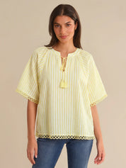 Woman wearing a yellow striped blouse with a beige background