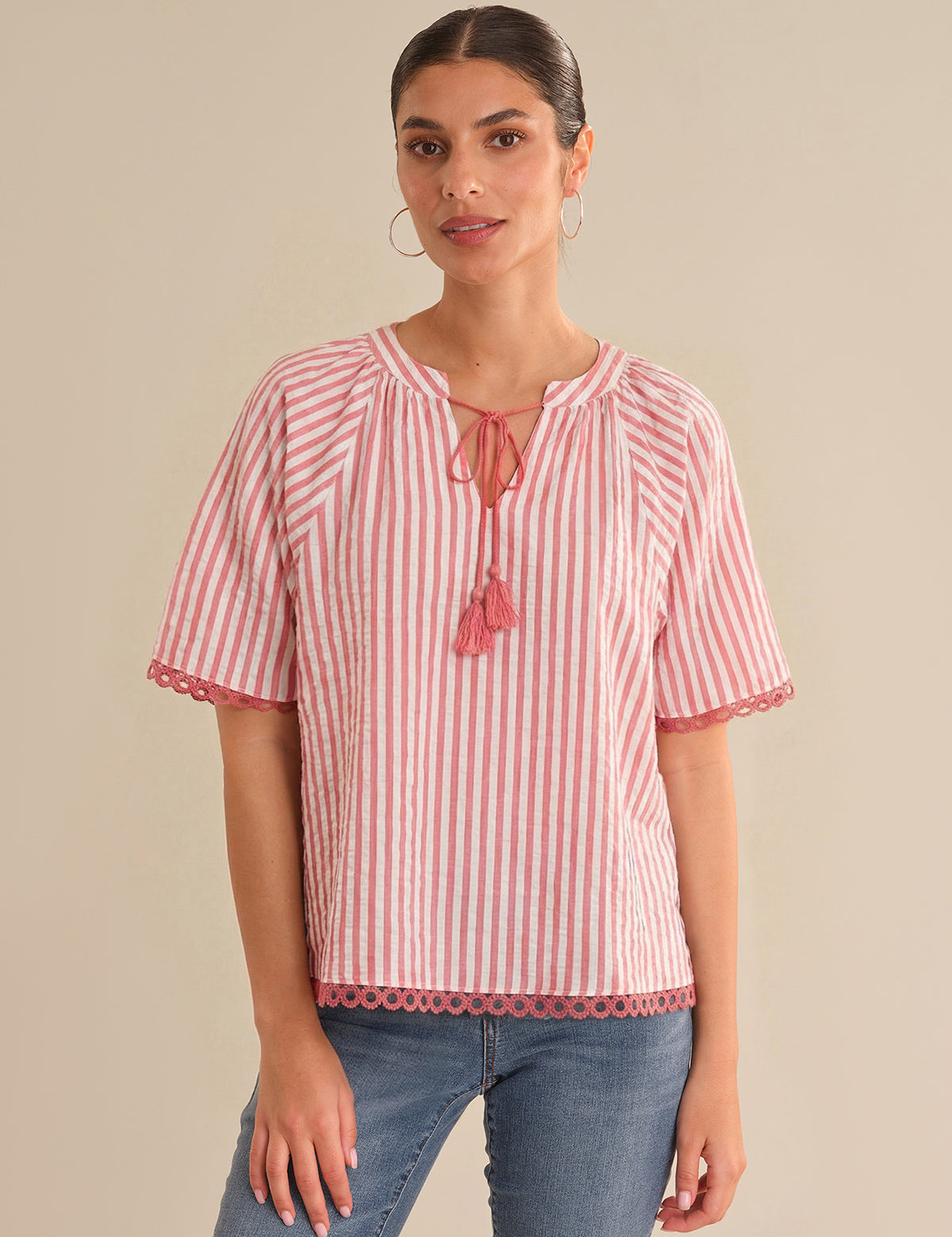 Woman wearing a red and white striped blouse with a beige background