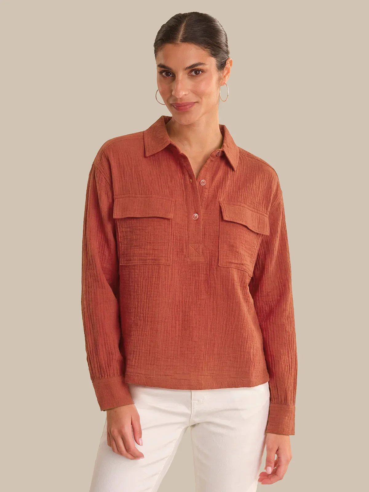 Woman wearing a rust-colored corduroy shirt against a beige background