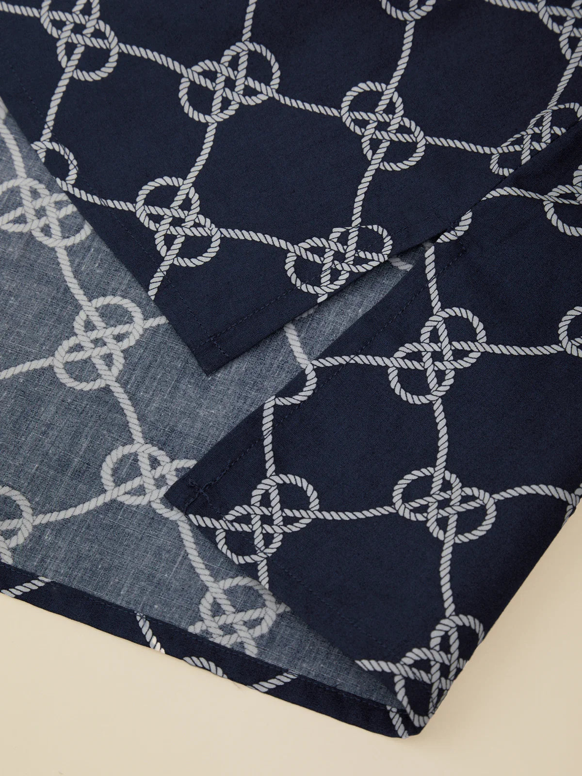 Navy and gray patterned fabric with interwoven design on a beige background